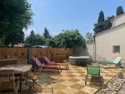 a patio with chairs and tables and a fence at Les Lavandières in Velleron