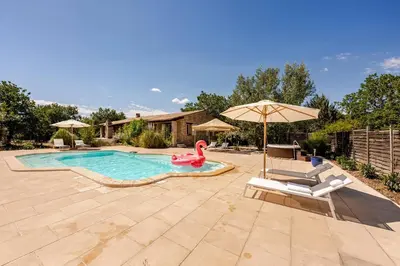a swimming pool with a pink flamingo and a swan in a yard at Gordes Villa avec piscine chauffée et privée , jacuzzi et pétanque calme in Gordes