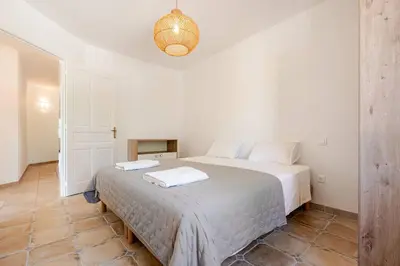 a bedroom with a bed with two towels on it at Gordes Villa avec piscine chauffée et privée , jacuzzi et pétanque calme in Gordes