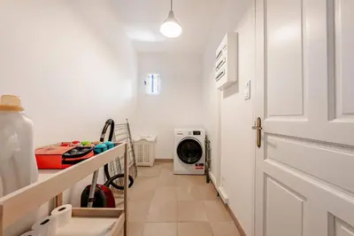 a hallway with a door and a washing machine at Gordes Villa avec piscine chauffée et privée , jacuzzi et pétanque calme in Gordes