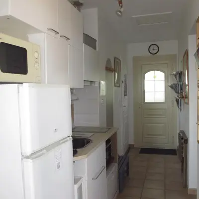 a kitchen with white appliances and a white door at Appartement les Balcons d'Azur in Vernègues