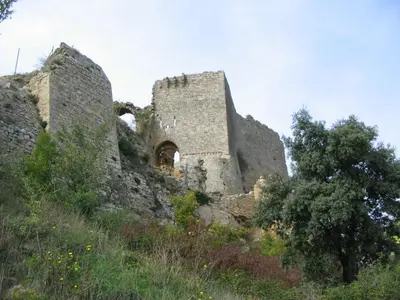 an old stone building on a hill with trees at Appartement les Balcons d'Azur in Vernègues