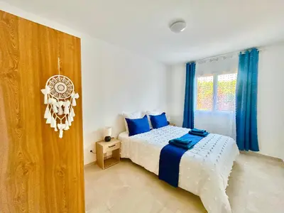 a bedroom with a bed with blue pillows and a window at Évasion Ventoux, villa spacieuse et accessible PMR in Carpentras