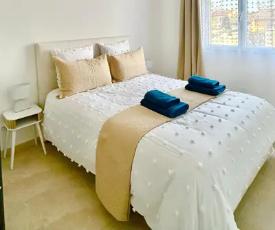 a white bed with two blue pillows on it at Évasion Ventoux, villa spacieuse et accessible PMR in Carpentras