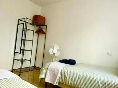 a room with two beds and a white wall at Évasion Ventoux, villa spacieuse et accessible PMR in Carpentras