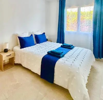 a white bed with blue pillows in a bedroom at Évasion Ventoux, villa spacieuse et accessible PMR in Carpentras