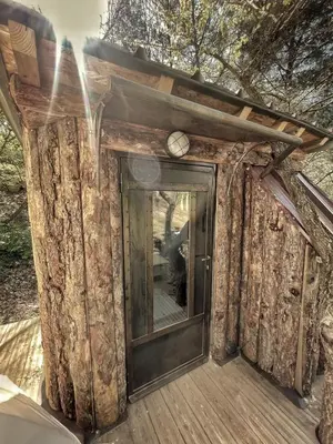 a front door of a log cabin with a clock on it at Tipi à Roussillon in Roussillon