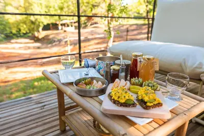 a wooden table with food and drinks on a porch at Tipi à Roussillon in Roussillon