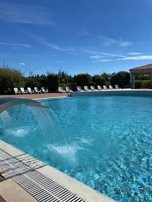a swimming pool with a fountain in the middle of it at Maison aux Demeures du Ventoux in Aubignan