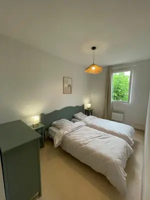 a bedroom with two beds and a table and a window at Maison aux Demeures du Ventoux in Aubignan