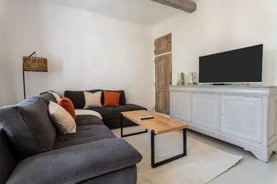 a living room with a couch and a flat screen tv at L’oustaou de Ventabren Village Square in Ventabren