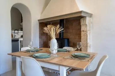 a dining room table with chairs and a vase on it at L’oustaou de Ventabren Village Square in Ventabren