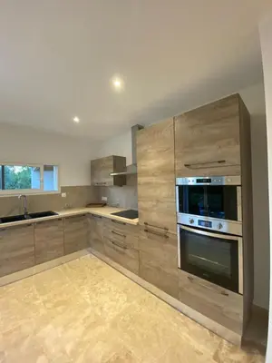 a large kitchen with wooden cabinets and an oven at La Maison Myssa in Apt
