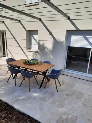 a wooden table and chairs on a patio at La Maison Myssa in Apt