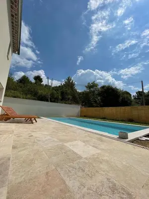 a swimming pool with a chair next to a house at La Maison Myssa in Apt