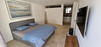 a bedroom with a bed with blue sheets and a television at Quiet, discreet places in Vernègues