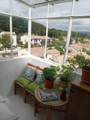 a balcony with a couch and a table with plants at T3 campagne d'Aix-en-Provence in Meyrargues