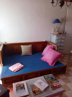 a bed in a room with a table and pink pillows at T3 campagne d'Aix-en-Provence in Meyrargues