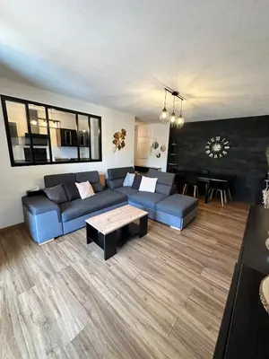 a living room with a blue couch and a table at Appartement calme et spacieux à Aix en Provence in Aix-en-Provence