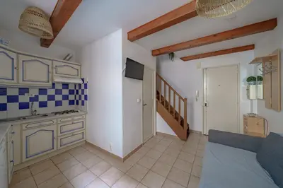 a living room with a kitchen and a couch at Apparemment hypercentre Aix-en-Provence in Aix-en-Provence