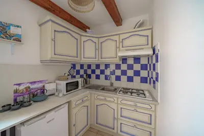 a small kitchen with white cabinets and a microwave at Apparemment hypercentre Aix-en-Provence in Aix-en-Provence