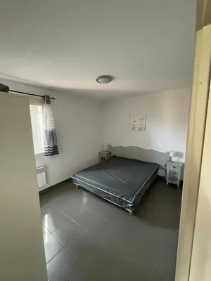 a bedroom with a bed in the corner of a room at Maison aux Demeures du Ventoux Adaptée PMR in Aubignan