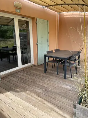 a picnic table on a deck with a patio at Maison aux Demeures du Ventoux Adaptée PMR in Aubignan
