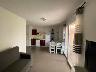 a living room with a couch and a kitchen at Maison aux Demeures du Ventoux Adaptée PMR in Aubignan