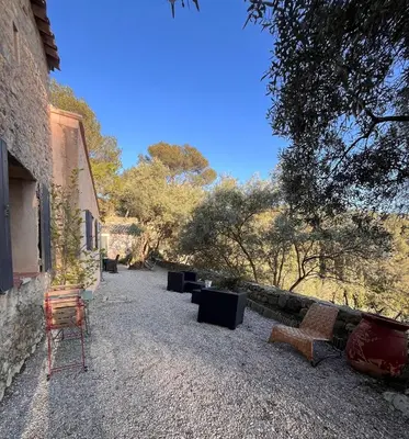 a chair sitting in a yard next to a building at Aix-en-Provence, Bastidon provençal plein cœur de la forêt avec vue unique in Le Tholonet