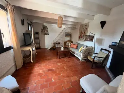 a living room with a couch and a tv at Aix-en-Provence, Bastidon provençal plein cœur de la forêt avec vue unique in Le Tholonet