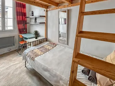 a bedroom with a bunk bed and a desk at T2 charmant avec mezzanine au cœur d'Aix in Aix-en-Provence