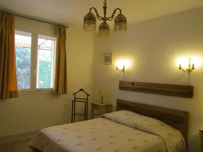 a bedroom with a bed and a window at Maison en PROVENCE in Robion en Luberon