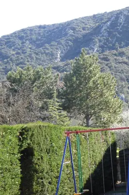 a swing in front of a hill with a tree at Maison en PROVENCE in Robion en Luberon