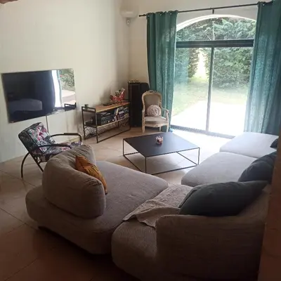 a living room with a couch and a large window at Charming house Saint Remy de Provence in Saint-Rémy-de-Provence