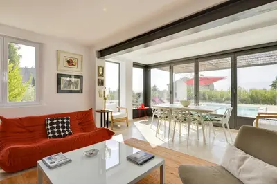 a living room with a red couch and a table at Villa Cali - Air-conditioned, Pool, Heart Village in Cabrières-dʼAvignon
