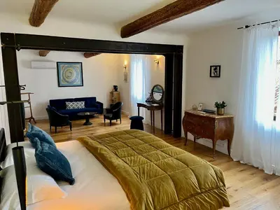 a bedroom with a bed and a living room at Suites de Bruoux in Gargas