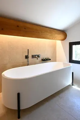 a large white bath tub in a room at Le Mazet de la Truffière in Gordes