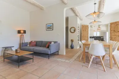 a living room with a couch and a dining room table at Villa Vue Luberon in Gordes
