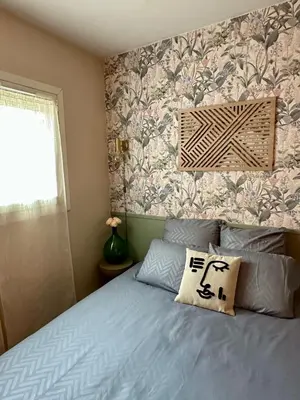 a bedroom with a blue bed with a floral wallpaper at 10 mn gare TGV Aix, parking gratuit & check-in autonome in Aix-en-Provence