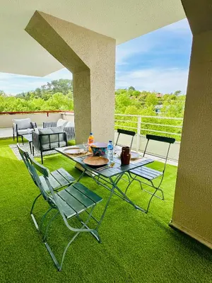 a patio with a table and chairs on the grass at 10 mn gare TGV Aix, parking gratuit & check-in autonome in Aix-en-Provence