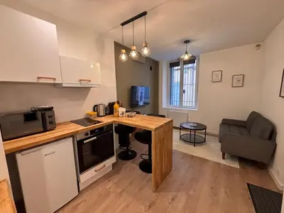 a kitchen with a counter and a table in a room at Charmant appartement aixois in Aix-en-Provence