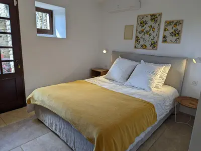 a bedroom with a bed with a yellow blanket at Mas traditionnel à Gordes en pleine nature in Gordes