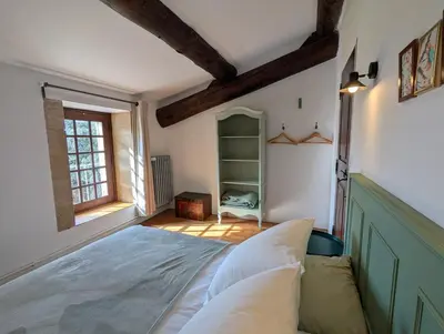 a bedroom with a large bed and a window at Mas traditionnel à Gordes en pleine nature in Gordes