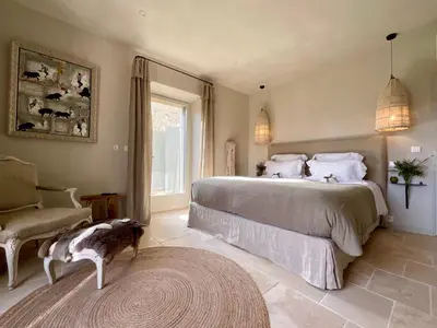 a bedroom with a large bed and a dog in it at Provence km28 in Gordes