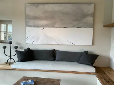 a living room with a couch and a painting on the wall at Provence km28 in Gordes