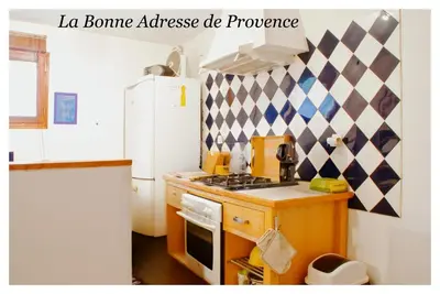 a kitchen with a white refrigerator and a stove top oven at La Bonne Adresse - Gite ZENITUDE in Cornillon-Confoux