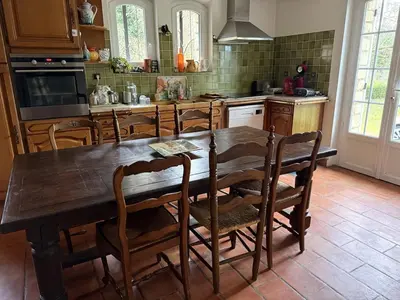 a kitchen with a large wooden table and chairs at Villa Provençale avec piscine in Pernes-les-Fontaines