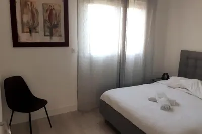 a bedroom with a bed and a chair and a window at Appartement Aix, résidence calme avec piscine in Aix-en-Provence