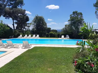 a large swimming pool with chairs and a lawn at Appartement Aix, résidence calme avec piscine in Aix-en-Provence