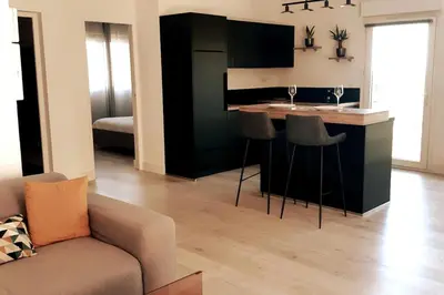 a living room with a kitchen with a bar with stools at Appartement Aix, résidence calme avec piscine in Aix-en-Provence